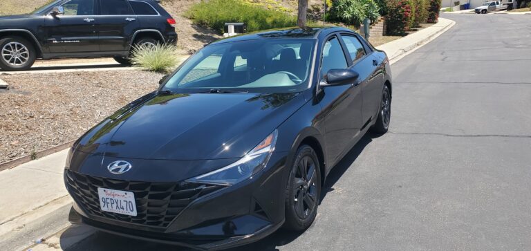 A freshly washed car shining in a driveway